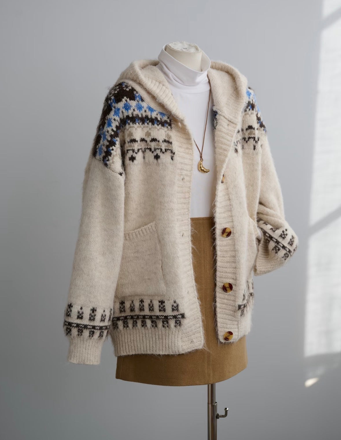 Cream Nordic Fair Isle hooded wool & alpaca blend cardigan with pockets, styled on a mannequin.