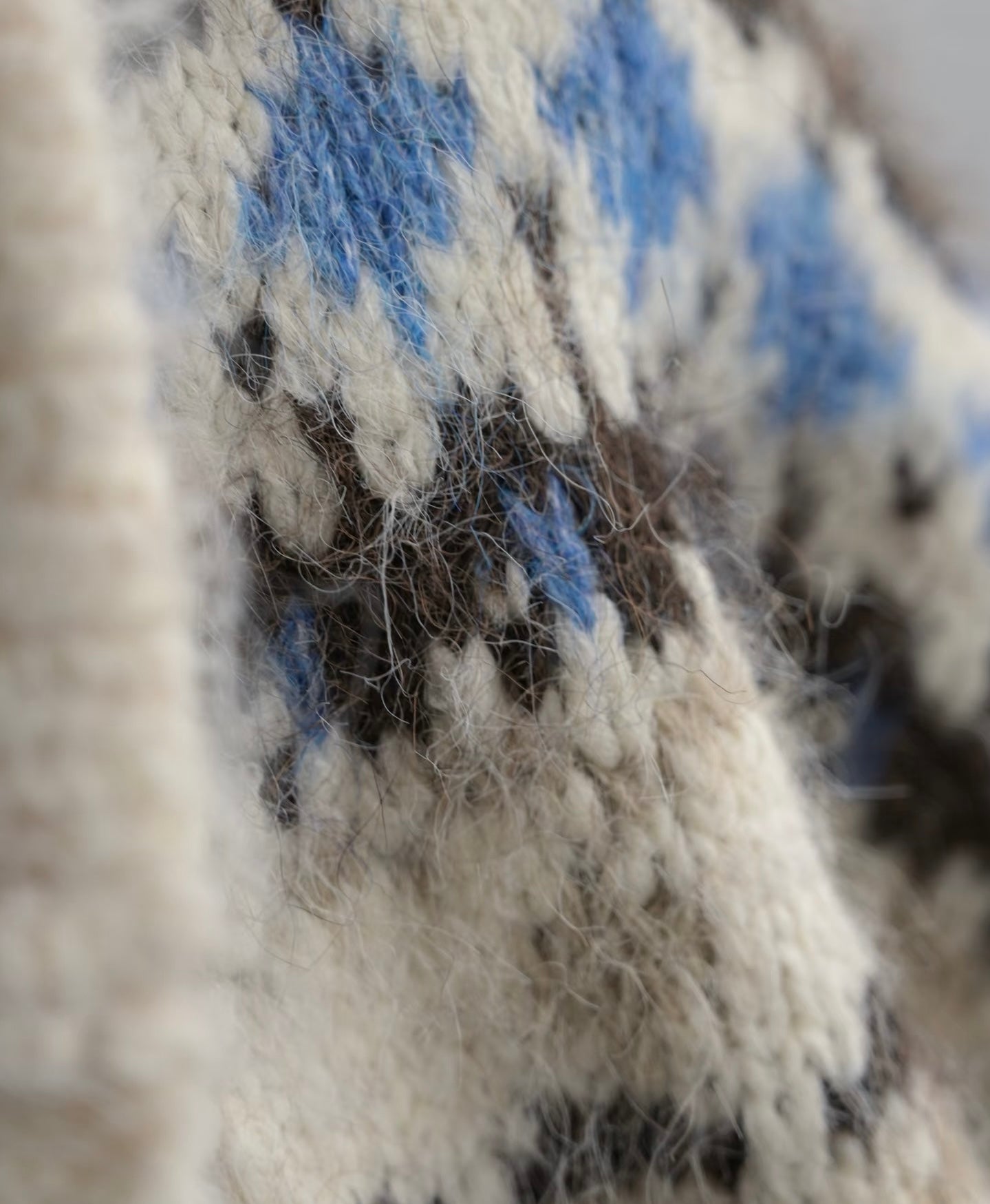 Close-up of a textured fabric with blue and black patterns on a neutral background