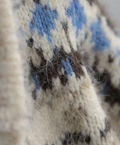 Close-up of a textured fabric with blue and black patterns on a neutral background