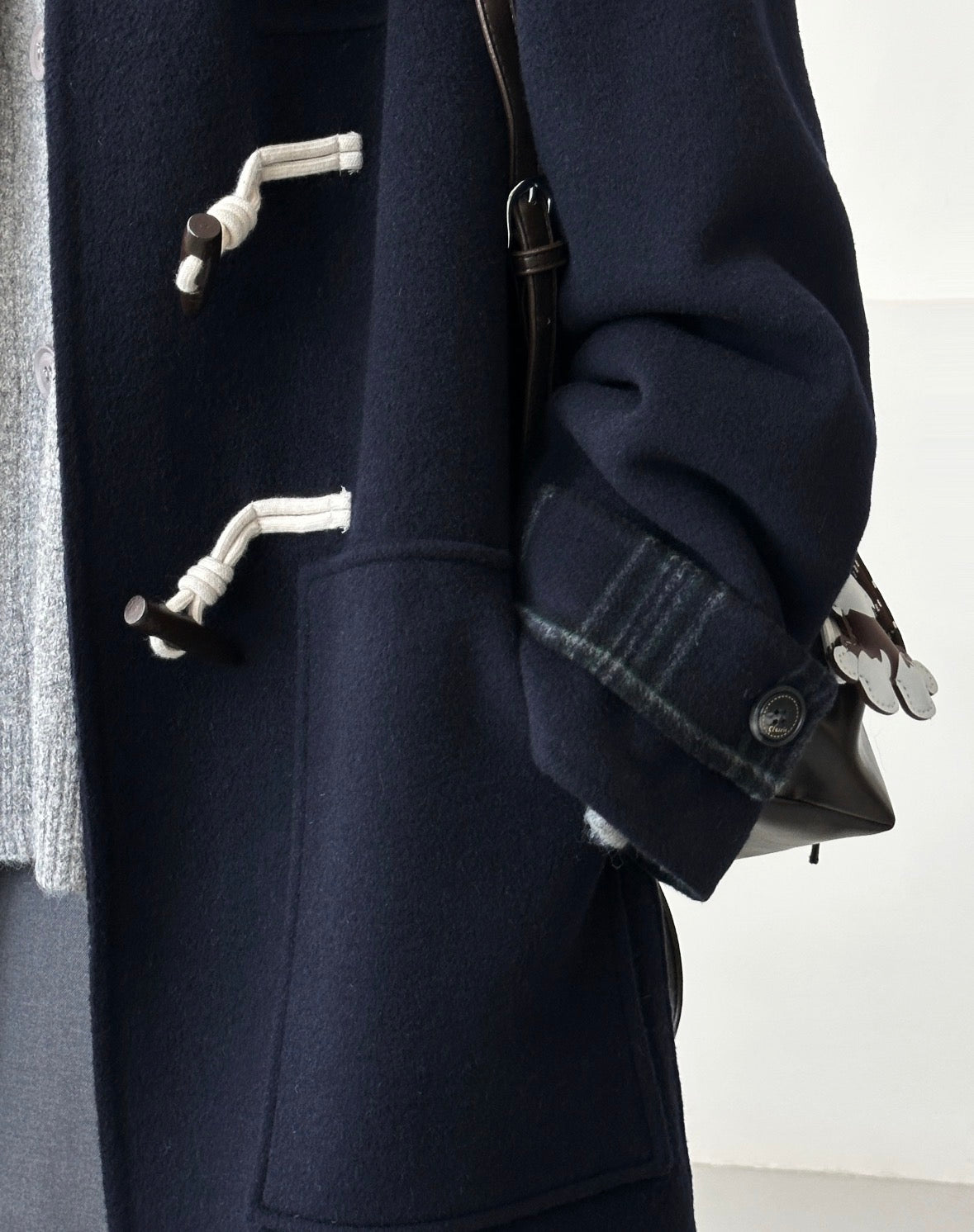 Navy Fern double-faced wool duffle coat with toggle closures and plaid cuff detail.