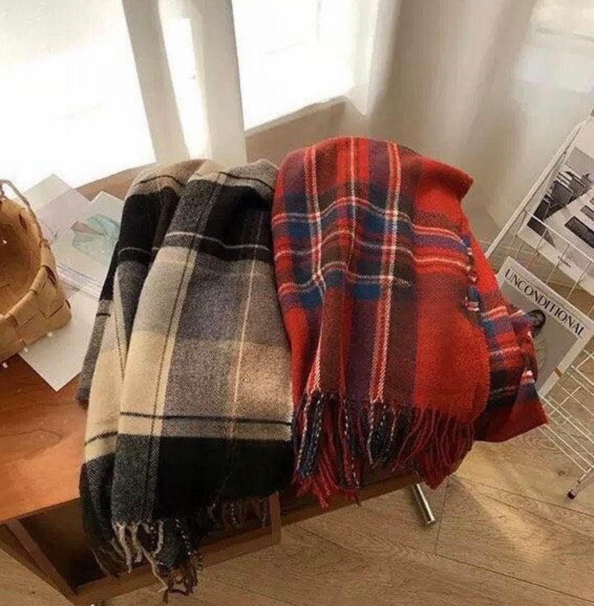 Two 100% wool plaid scarves: one red, blue, and white; the other black, white, and beige. Both have fringe.