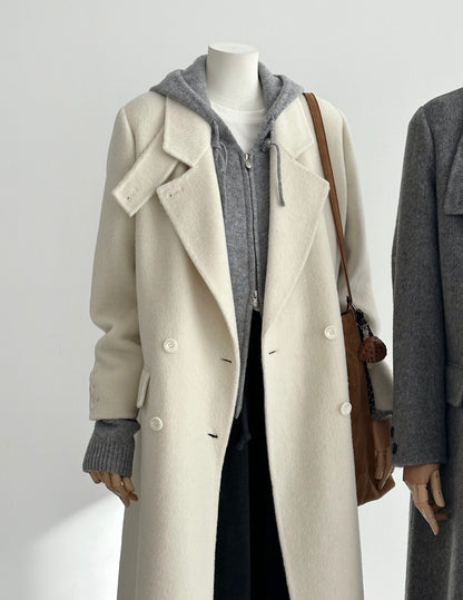 Ivory tailored wool coat with double-breasted front, convertible collar, and structured shoulders.