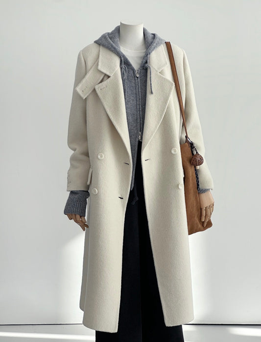 Ivory tailored wool coat with double-breasted front, convertible collar, and structured shoulders.