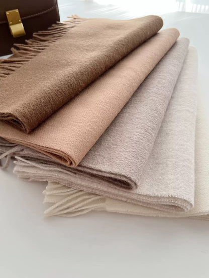 Emma 100% wool solid color scarves in shades of brown, beige, and cream, folded to show soft texture and fringe.