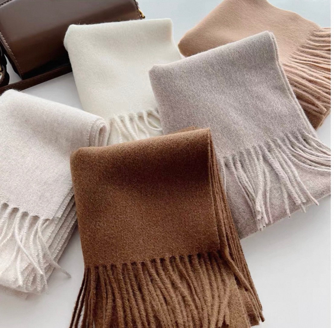 Emma 100% wool solid color scarves in cream, beige, light gray, and brown, with fringe details.