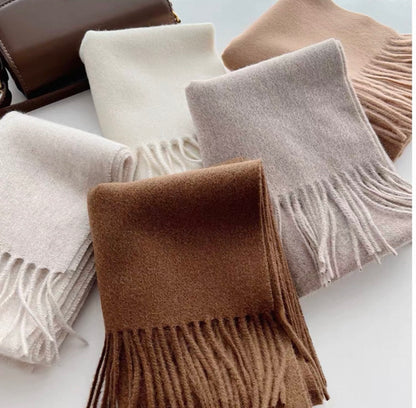 Emma 100% wool solid color scarves in cream, beige, light gray, and brown, with fringe details.